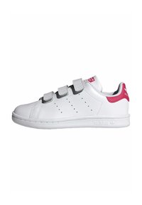 Baskets blanches avec une tige en cuir lisse, des bandes Velcro grises et un accent rose au talon. Présente des perforations sur le côté et une semelle texturée.