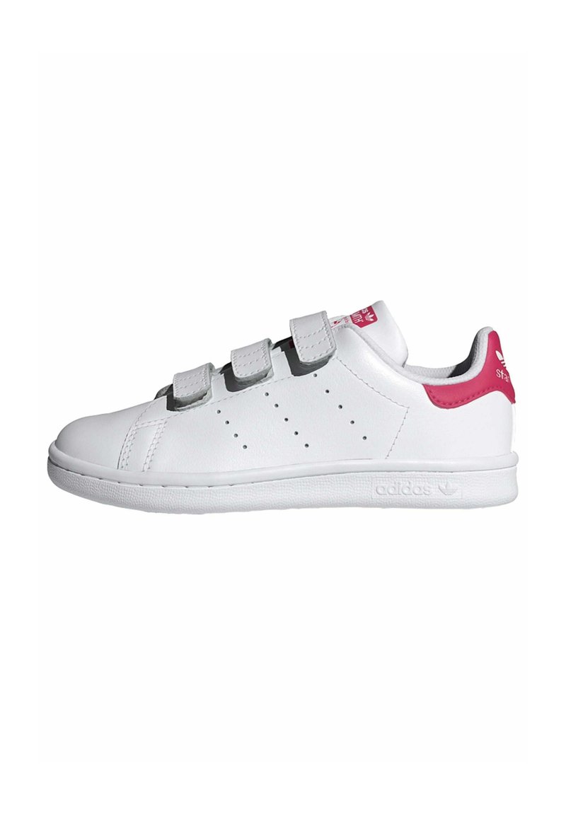 Baskets blanches avec une tige en cuir lisse, des bandes Velcro grises et un accent rose au talon. Présente des perforations sur le côté et une semelle texturée.
