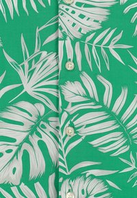 Groene stoffen shirt met witte tropische bladerenpatronen, met kleine knopen aan de voorkant en een soepele textuur.