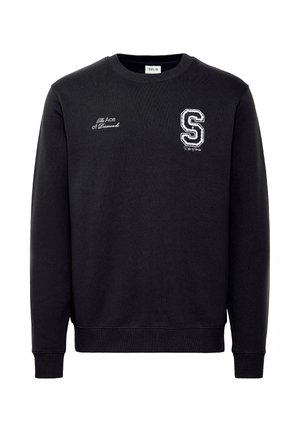 Fekete pulcsival, kerek nyakkal, hosszú ujjakkal, amelyen hímzett felirat található: "A Pikk Ász", valamint egy fehér "S" logó a mellrészen.