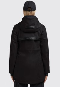 Sort vandtæt parka med aftagelig hætte, der har en indsnævret talje, et rygbælte med branding og elastiske manchetter.