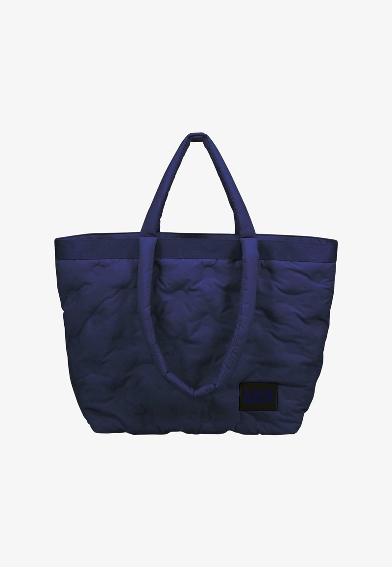 Borsa tote trapuntata blu navy con due manici in tessuto e base rettangolare. Presenta un piccolo etichetta nera con il testo "STUDIO BERLIN".