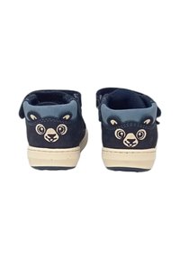 Scarpe in suede blu navy con design di faccia d'orso sui talloni, dotate di accenti azzurri e suola in gomma beige. Chiusura con cinturino regolabile.