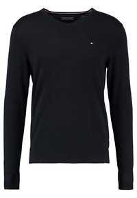 Schwarzer V-Ausschnitt-Pullover aus weichem Stoff. Besitzt lange Ärmel und gerippte Bündchen, mit einem kleinen Logo-Emblem auf der Brust. Einfaches Design.