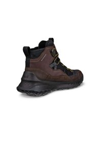 Stivali da trekking impermeabili marroni a metà altezza con accenti neri, superficie testurizzata, suola in gomma spessa e lacci gialli per un tocco in più.