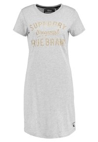 Harmaa puuvillapuseromekko, jossa on lyhyet hihat, pyöreä kaulus ja kultaisista paljeteista tehty teksti "SUPERDRY Original TRUE BRAN."