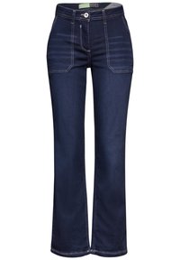 Jeans in denim blu navy con un design a gamba svasata, dotati di tasche frontali e cuciture bianche a contrasto su cuciture e tasche.