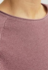 Licht mauve gebreide trui met een ruime halslijn en textuurpatroon, met fijne ribbeldetails langs de halslijn en naden.