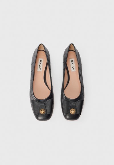 Ballerines noires en cuir avec un design matelassé, bout rond et un accent logo doré à l'avant. Doublure intérieure de couleur claire.