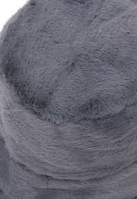 Cappello in finta pelliccia grigia con una consistenza morbida, forma cilindrica e superficie liscia. Presenta una fascia di un colore leggermente più scuro attorno alla base.