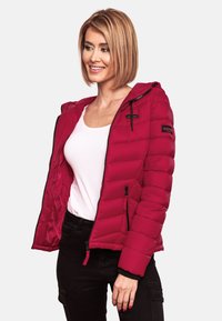 Red puffer jacket with a hood, featuring a zippered front and two side pockets. Made from quilted material with elastic cuffs and notable branding.