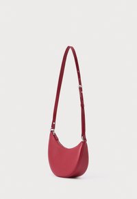 Piros bőr válltáska, félhold alakú, állítható pánttal és sima felülettel. Cipzáras záródással és minimális fém díszítéssel rendelkezik.