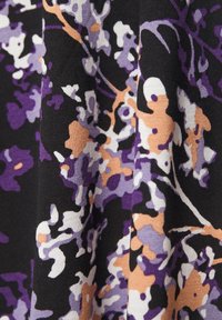 Sort stof med abstrakt blomsterpattern i lilla, hvide og ferskenfarver, der skaber et tekstureret, lagdelt udseende.