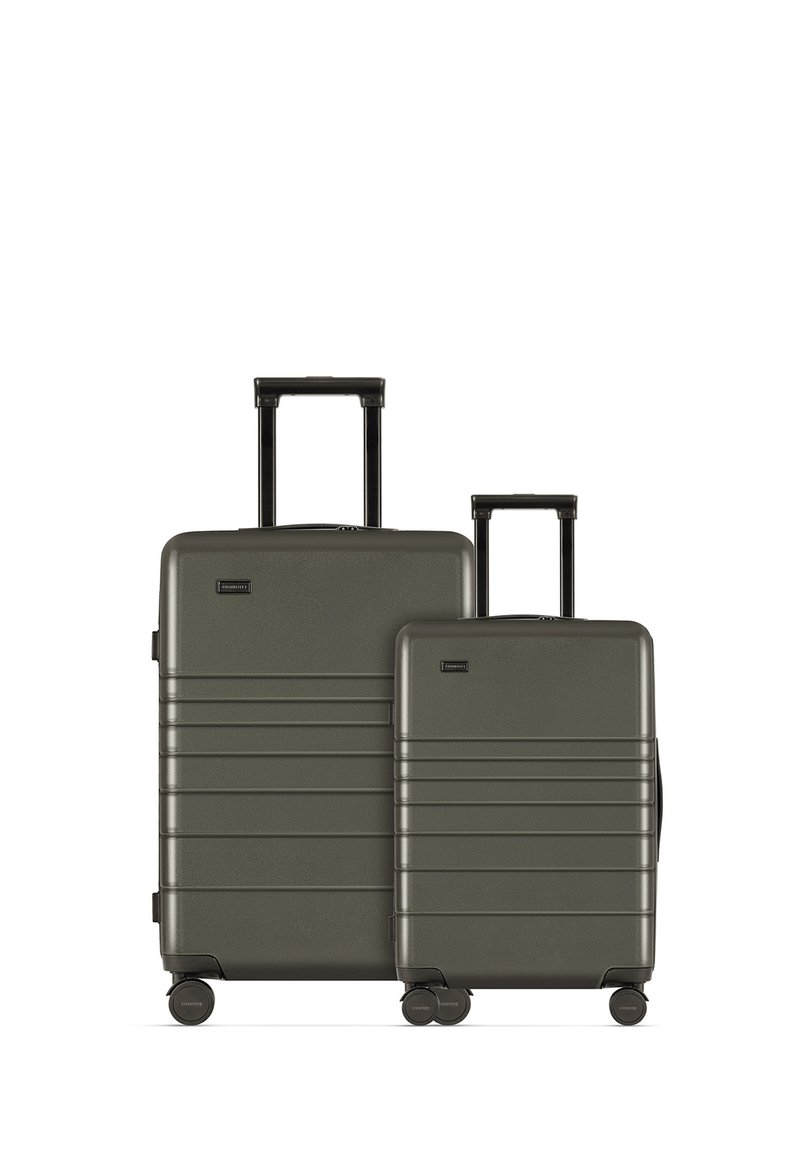 Twee harde koffers in donkergroen, met een gestructureerd oppervlak, horizontale groeven en een uitschuifbare handgreep op elke koffer.
