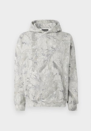 Sudadera con capucha de color gris claro, con un sutil patrón de camuflaje de ramas y hojas, bolsillo frontal tipo canguro y puños acanalados.