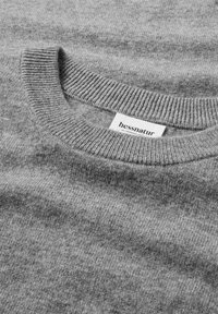 Maglione grigio a maglia con collo a girocollo a coste e etichetta. La morbidezza della trama, il motivo uniforme e il design minimalista mettono in risalto il suo tessuto naturale.