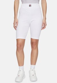 Shorts da ciclismo bianchi a coste con vita alta e un piccolo logo nero e rosso. Il materiale sembra elastico e aderente.