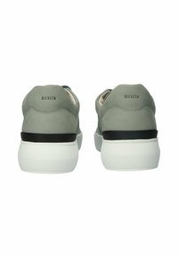 Šedé suede tenisky s hladkým povrchem, vybavené bílou podrážkou a černým akcentem kolem základny, označené "BLCKSTN" na patě.