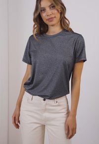 Šedé, metalické tričko s krátkým rukávem a volným střihem, s kulatým výstřihem, spárované se světle barevnými, slim-fit džíny.