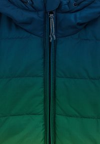 Izolovaná vatovaná bunda s prechodom farieb od tyrkysovej k tmavomodrej. Má zips na celej dĺžke, nastaviteľnú kapucňu a hladkú textúru látky s prešívaným vzorom.