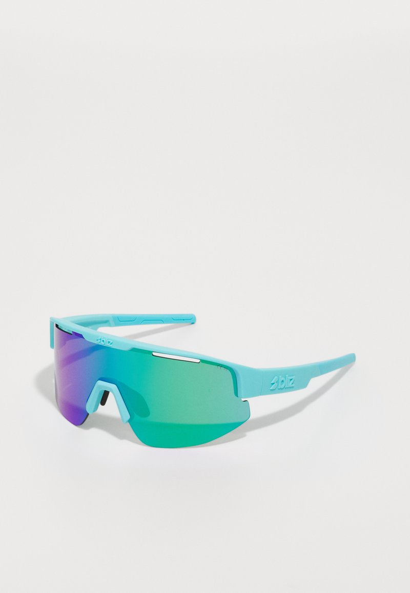 A pair of oversized sunglasses with a turquoise plastic frame and gradient lens transitioning from purple to green. Features angular design details.