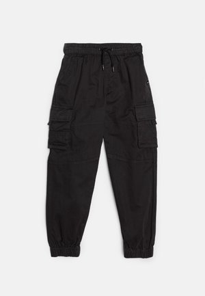 Pantalon cargo noir avec taille et poignets élastiques, poches latérales à rabats et cordon à la taille.
