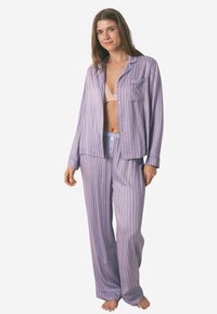 Ensemble de pyjama rayé en violet clair et rose. Chemise à boutons avec poche, pantalons amples avec taille élastique, en tissu doux.