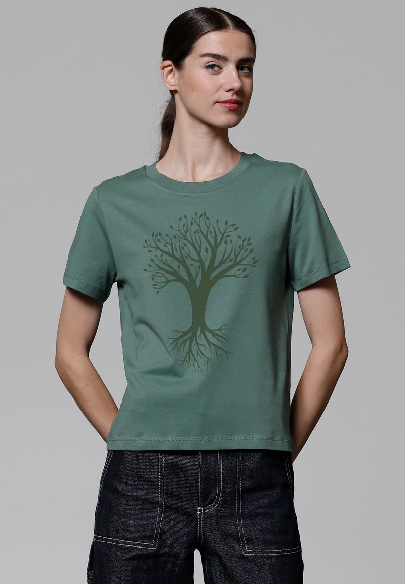 Grünes Baumwoll-T-Shirt mit kurzen Ärmeln, das ein dunkelgrünes Baumgrafikdesign in der Mitte aufweist. Rundhalsausschnitt, lockere Passform.