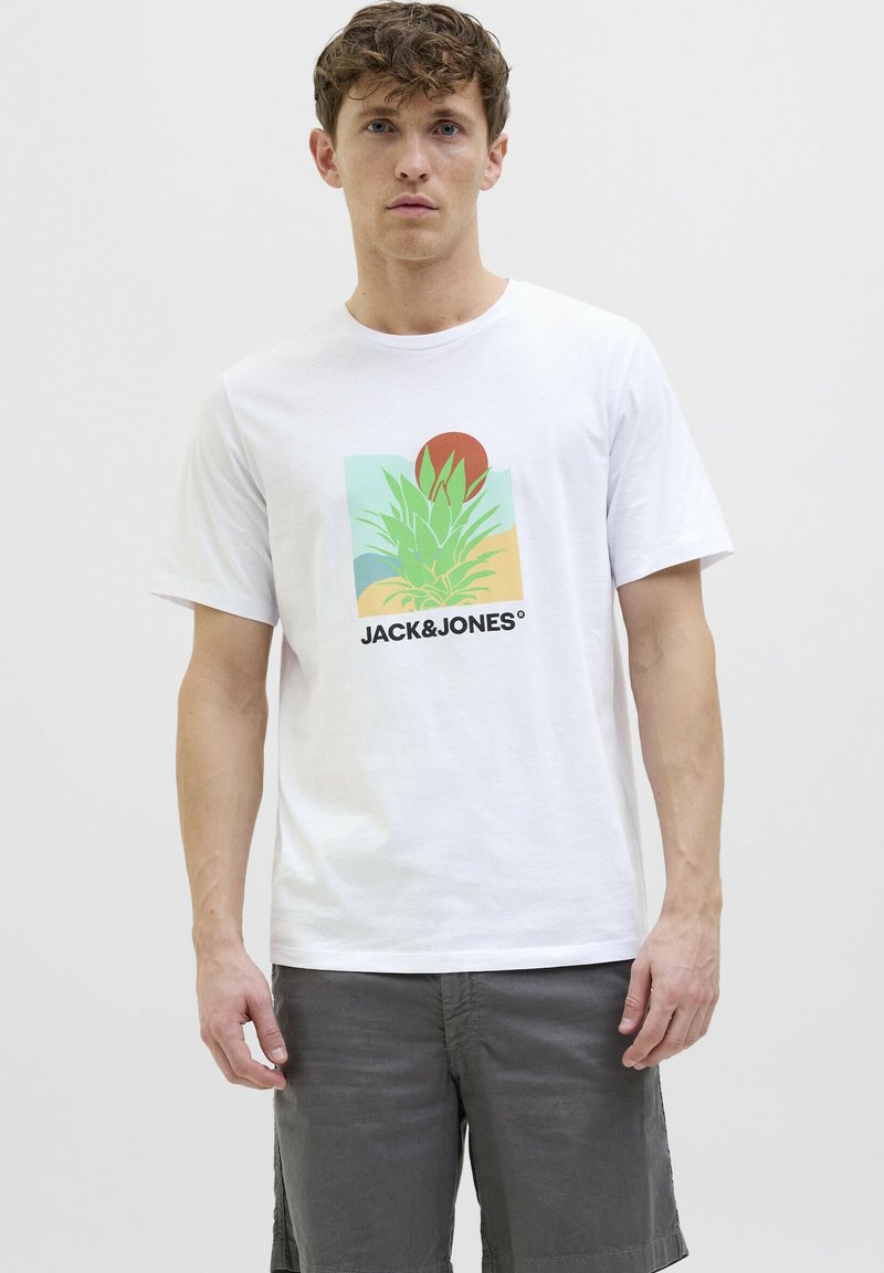 Camiseta de algodón blanca con un diseño gráfico colorido que presenta una planta verde, un sol rojo y el texto "JACK & JONES". Mangas cortas y cuello redondo.