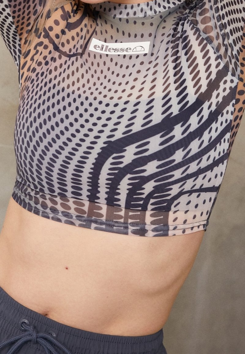 Průhledný cropped top v šedé barvě s abstraktními vzory v černé a hnědé, s kulatým výstřihem a elastickým lemem. Viditelný štítek značky.