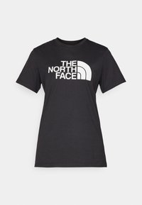 Mustmust värvi puuvillane T-särk, millel on suur valge "THE NORTH FACE" logo ja kaarene aksent. Lühikesed varrukad ja ümmargune kaelus, sile tekstuur.