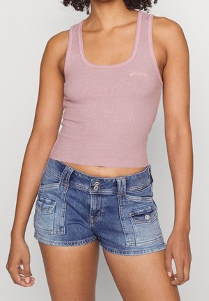 Žebrovaný světle růžový krátký top s širokými ramínky, doplněný džínovými šortkami s vybledlým modrým odstínem a dvěma předními kapsami.