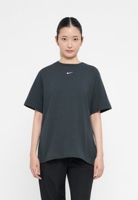 Melnas īsu piedurkņu T-krekls, izgatavots no kokvilnas, ar apaļu kakla izgriezumu, ar baltu Nike logotipu uz krūtīm. Vienkāršs, brīvs piegriezums.
