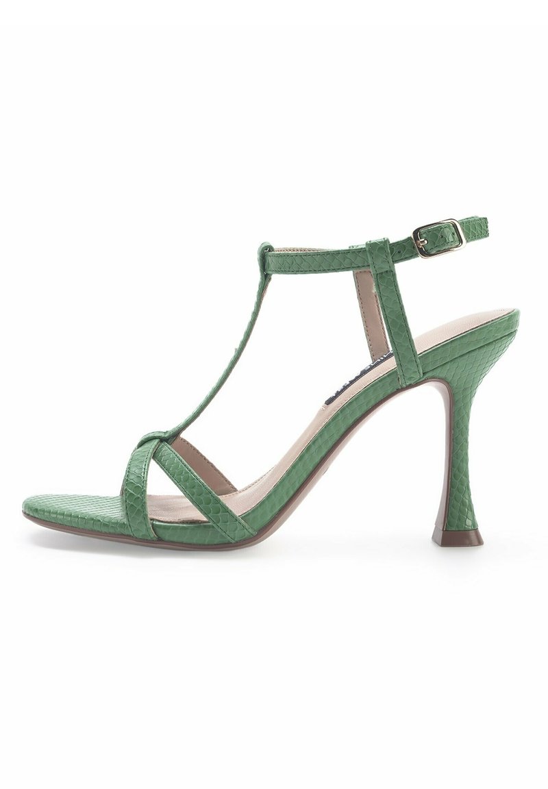 Sandale à talon haut verte avec bride en T et boucle à la cheville, présentant un motif texturé effet peau de serpent et un design à bout ouvert.