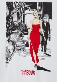 Maglietta bianca con design grafico che raffigura una donna in abito rosso e un uomo in smoking, con uno sfondo dettagliato di mobili e piante.