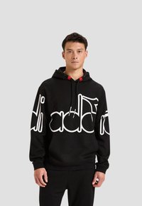 Felpa con cappuccio nera in misto cotone con grande logo bianco sul petto, dettaglio rosso sui lacci e tasca a marsupio.