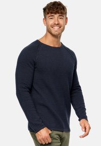 Camisa de manga larga texturizada en color navy con rayas horizontales y mangas raglán, con cuello redondo y puños ajustados.