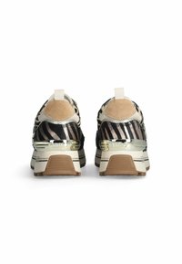 Zapatillas con una parte superior de estampado de cebra en negro y beige, acentos de ante suave, herrajes metálicos y una suela blanca gruesa con tracción marrón.