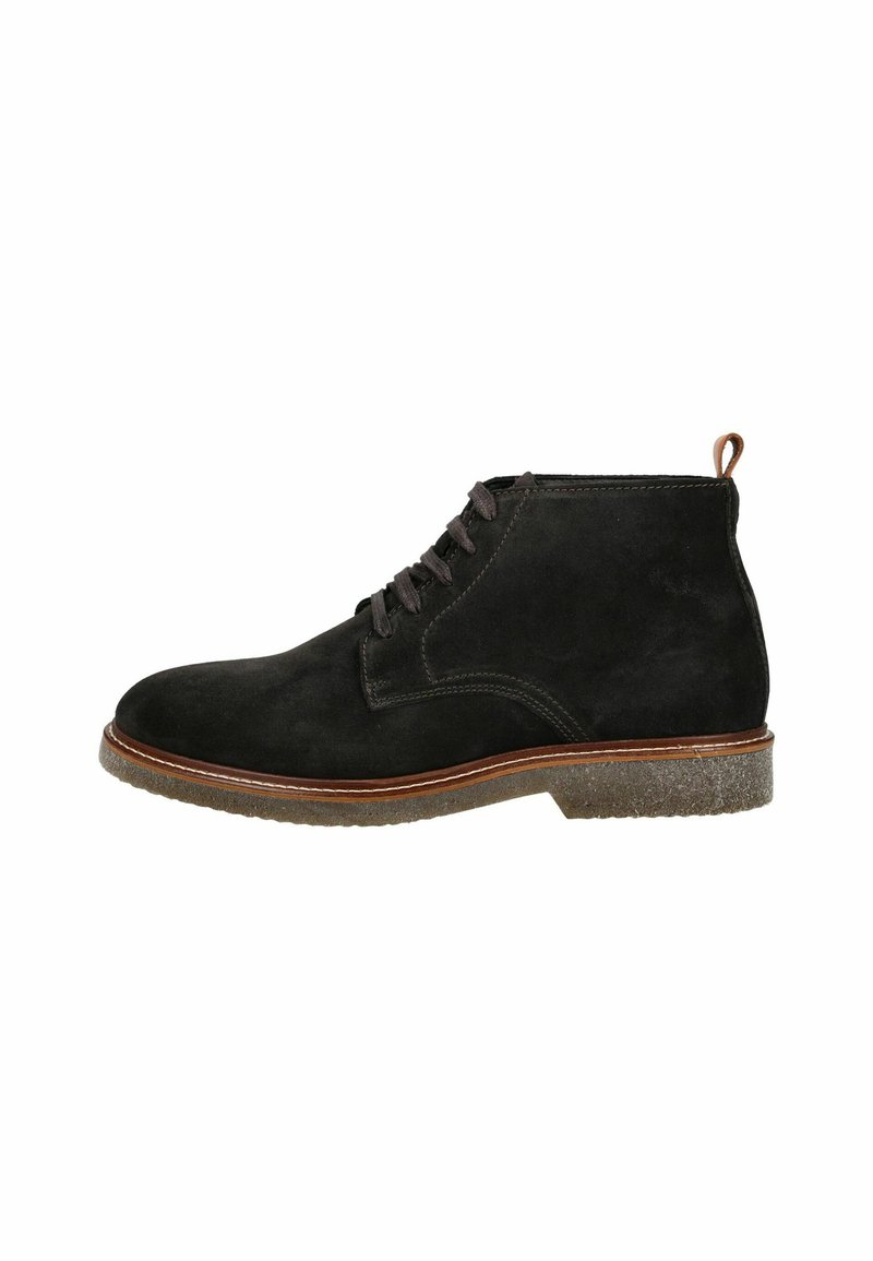 Stivali alla caviglia in suede nero con punta arrotondata, stringati frontalmente e con un accento in pelle marrone sul tallone. Suola in gomma testurizzata con un bordo beige.