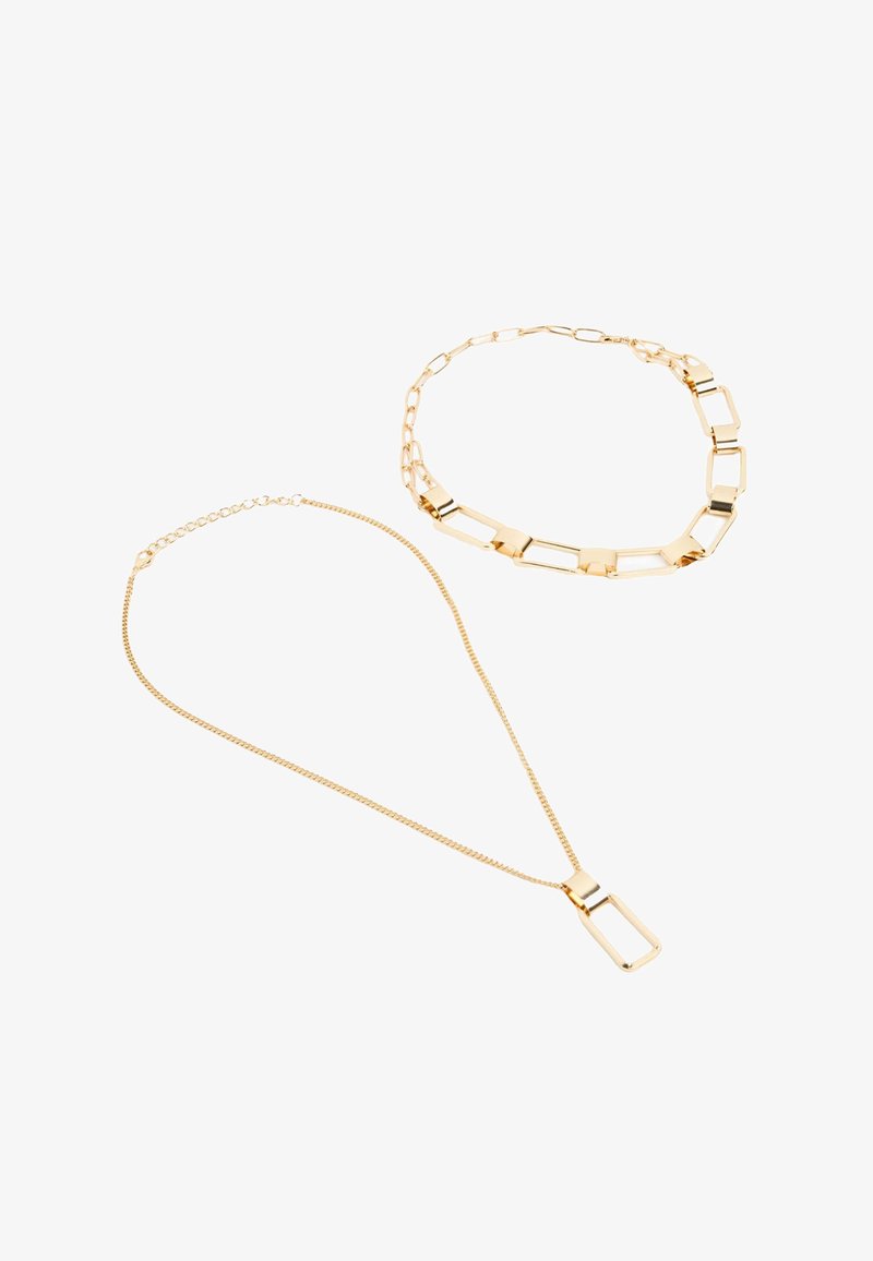 Set di gioielli in oro composto da una collana con ciondolo rettangolare e un choker a catena, entrambi con superfici lucide e riflettenti.