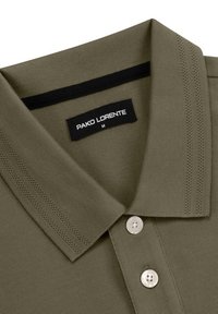 Oliwkowa koszulka polo z teksturowanej tkaniny, trzy srebrne guziki i czarny akcent na kołnierzyku; metka głosi "PAKO LORENTE", rozmiar M.