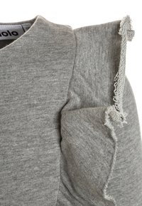 Grauer Pullover mit weicher Struktur, der ein einzigartiges Designelement an den Schultern und fransige Akzente an den Nähten aufweist.