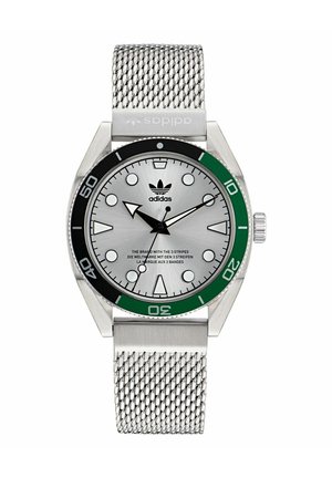 Montre en acier inoxydable argenté avec une lunette verte et noire. Bracelet en maille et un cadran argenté texturé avec des marqueurs et des aiguilles d'heure en gras. Logo Adidas affiché.