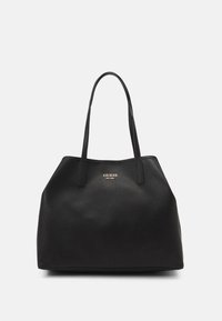 Sac fourre-tout noir en simili cuir texturé, avec deux longues poignées et un logo doré à l'avant. Design spacieux et structuré.