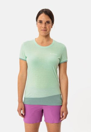 Hellgrünes, kurzärmliges Sportoberteil mit einem Verlaufsdesign und rundem Halsausschnitt, kombiniert mit lila Shorts. Dezentes Markenlogo auf der Brust.