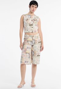 Set di top a corsetto e pantaloni corti caratterizzato da un motivo stampato di etichette vintage in vari colori, con chiusura a bottone e tasche.