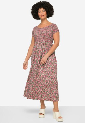 Robe maxi à manches courtes, faite d'un tissu à motifs floraux montrant des teintes de rose et de vert. Comprend un corsage ajusté et une jupe fluide.