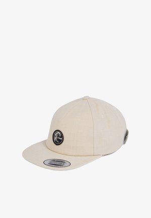 Beige verstelbare baseballpet met een vlakke rand, voorzien van een zwart rond logo-embleem en een zweetbanddetail. Gemaakt van textuurstof.