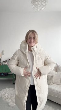 Ekrü puffert kabát magas gallérral, hosszú ujjakkal és cipzáras záródással. Az anyag puha és steppelt hatású, melegséget nyújt.