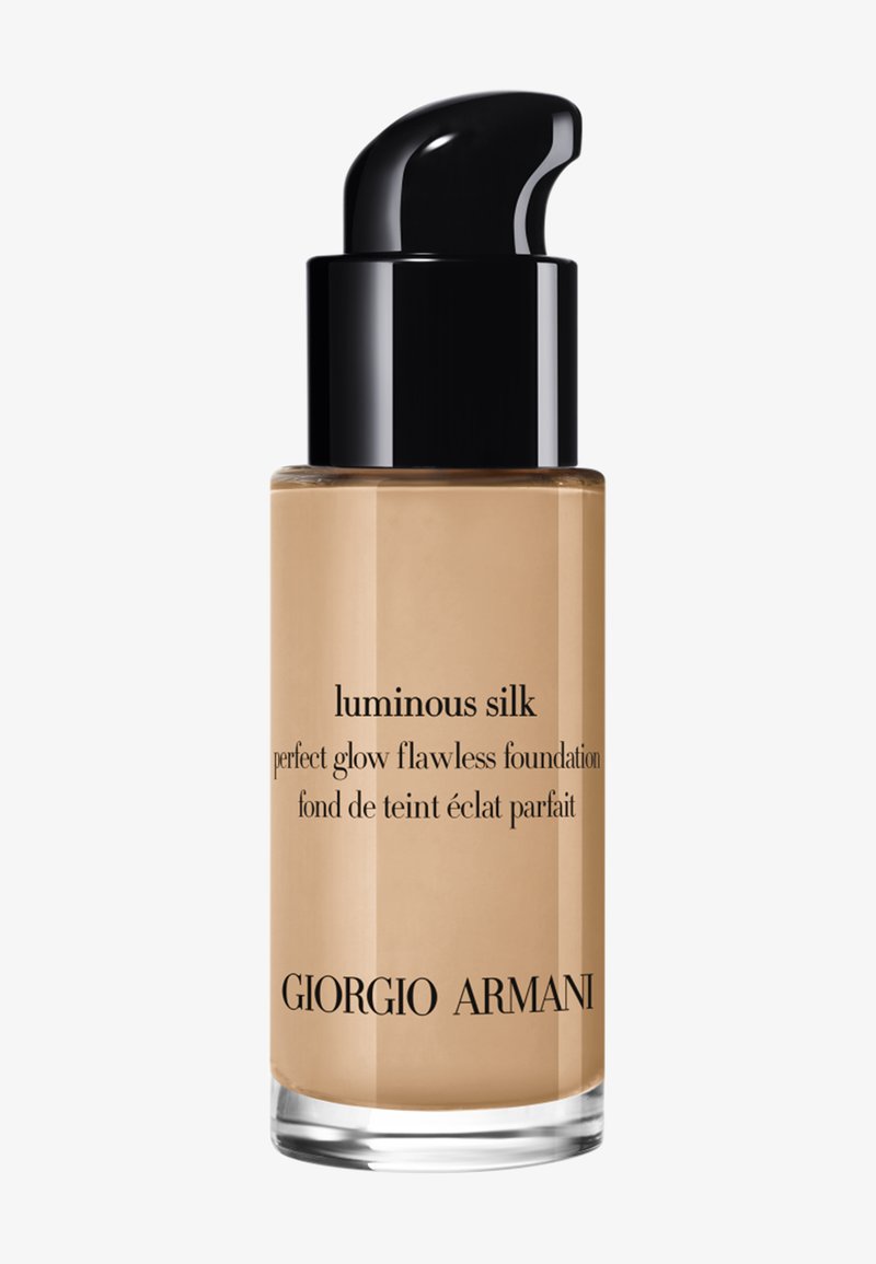 Fles Giorgio Armani Luminous Silk foundation met een zwarte pompdispenser en beige vloeistof zichtbaar aan de binnenkant.